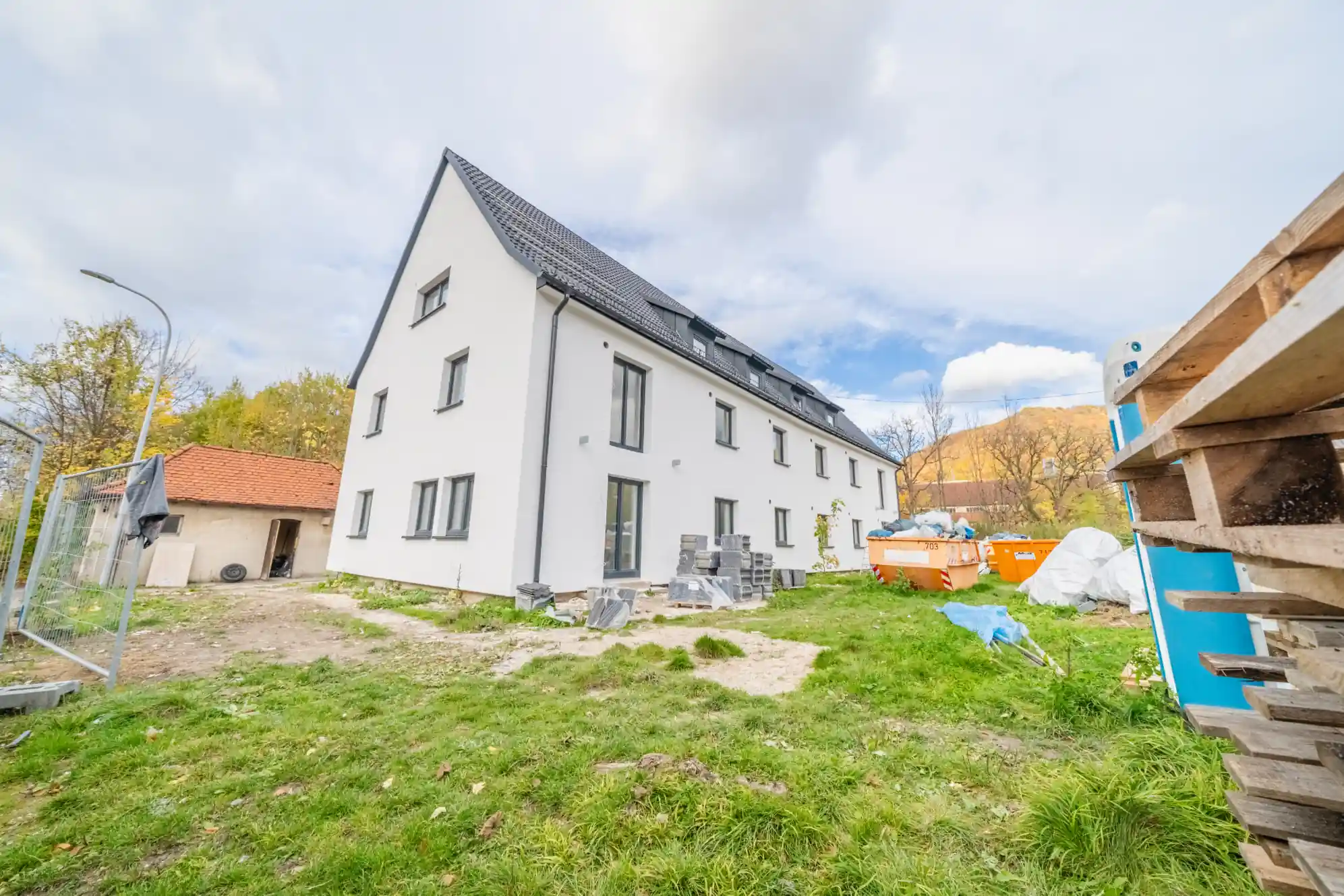 Dritte Bauphase — Neubau Lenningen nahezu fertiggestellt, weißer Putz und Satteldach, früher Herbst