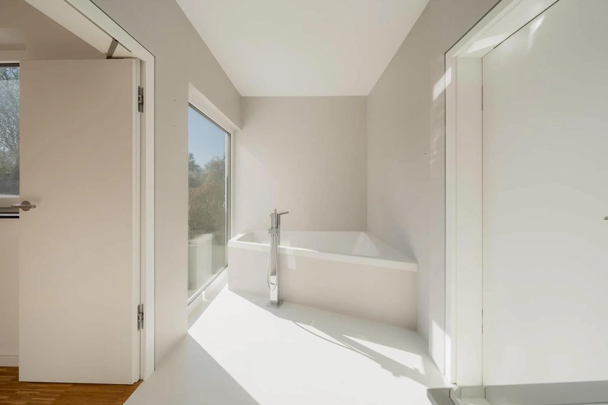 Minimalistisches Bad mit freistehender Badewanne und bodentiefer Glasfront — Bungalow Herrenberg, Immobilienfotografie MV Media