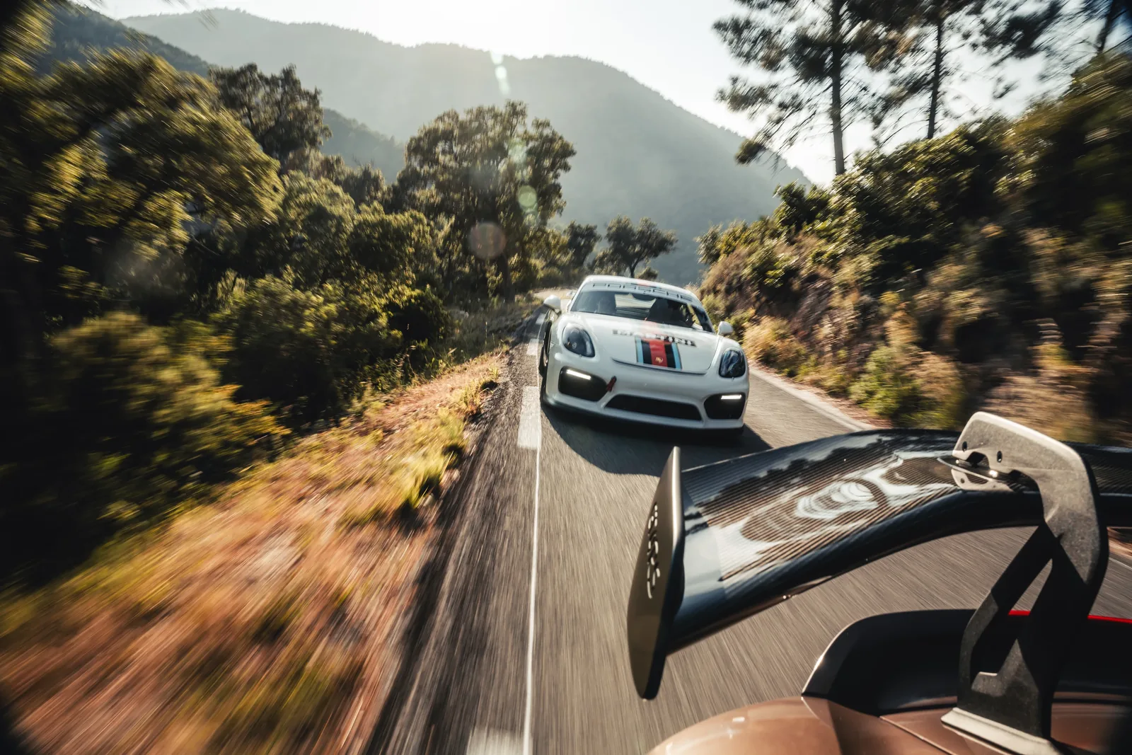 Car-to-Car-Aufnahme: Blick vom Begleitfahrzeug auf einen weißen Porsche — Automobilfotografie Maurice Veith