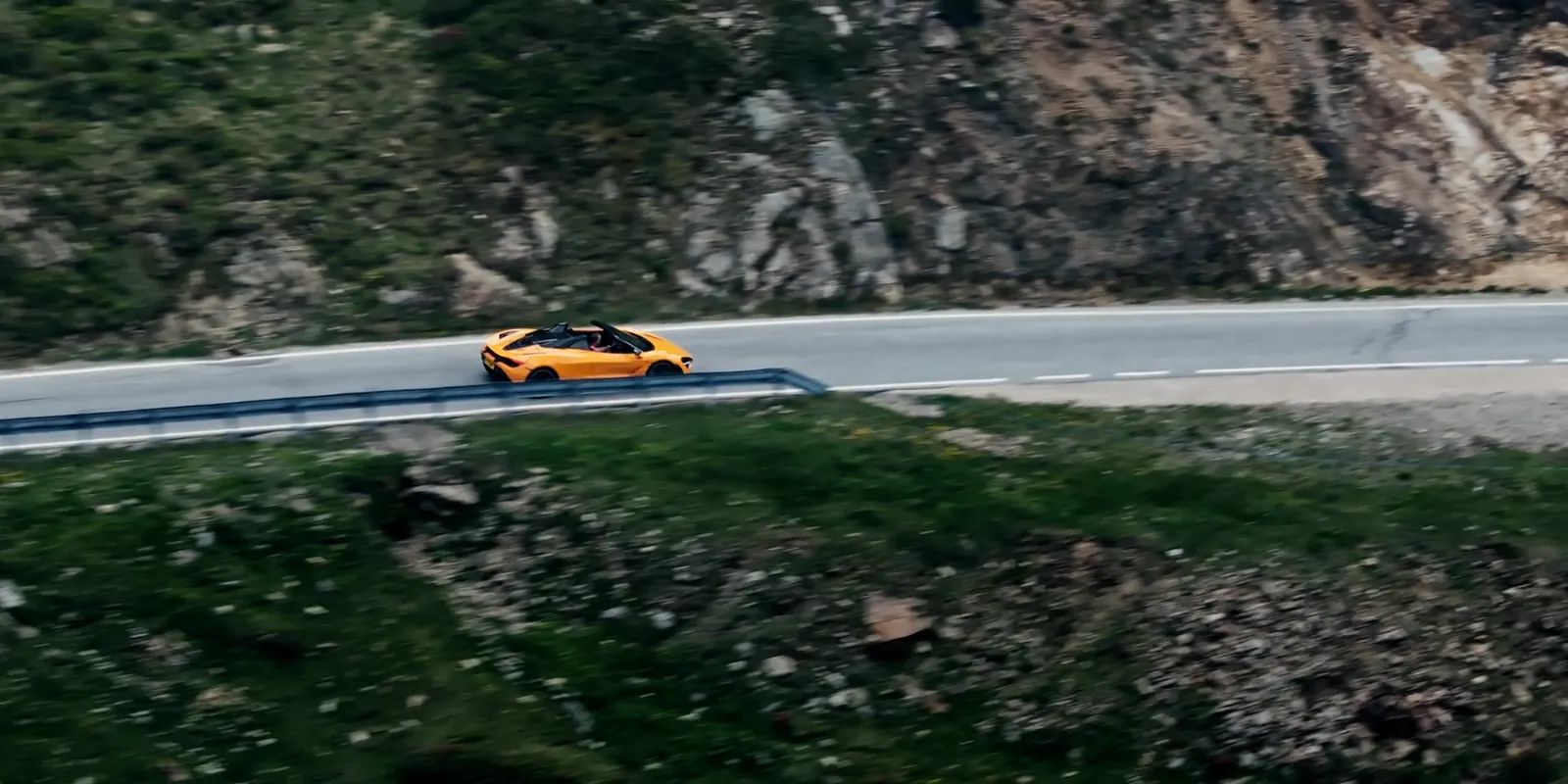 Oranger McLaren auf einer Serpentine in den Dolomiten aus der Luft — Standbild aus dem Event-Film von Maurice Veith