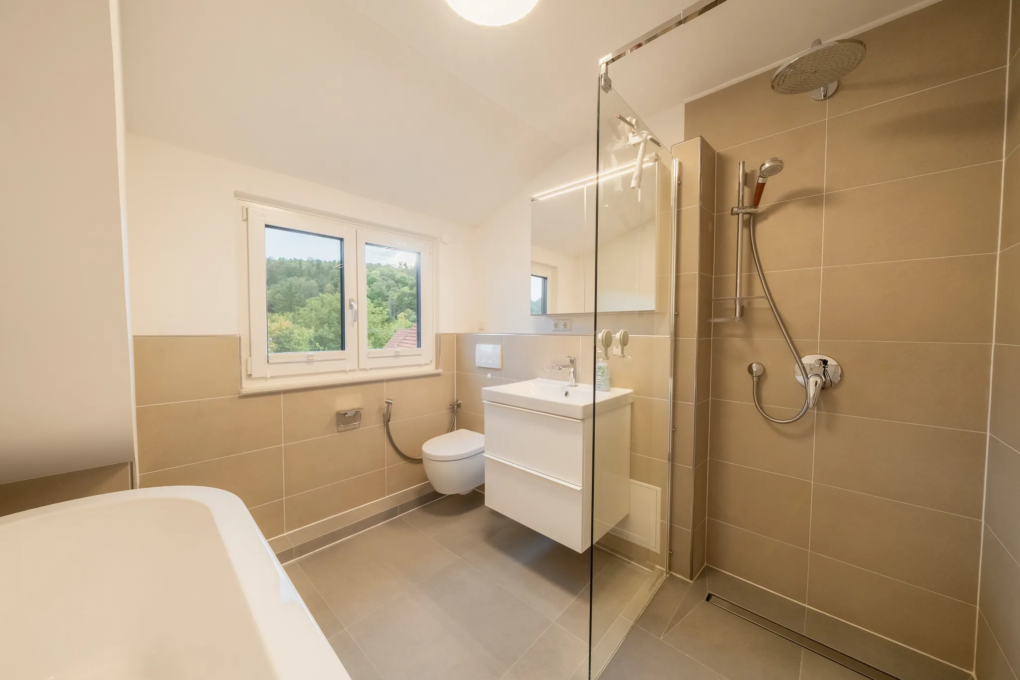 Bad mit Badewanne und Dusche unter der Dachschräge – Grafenau