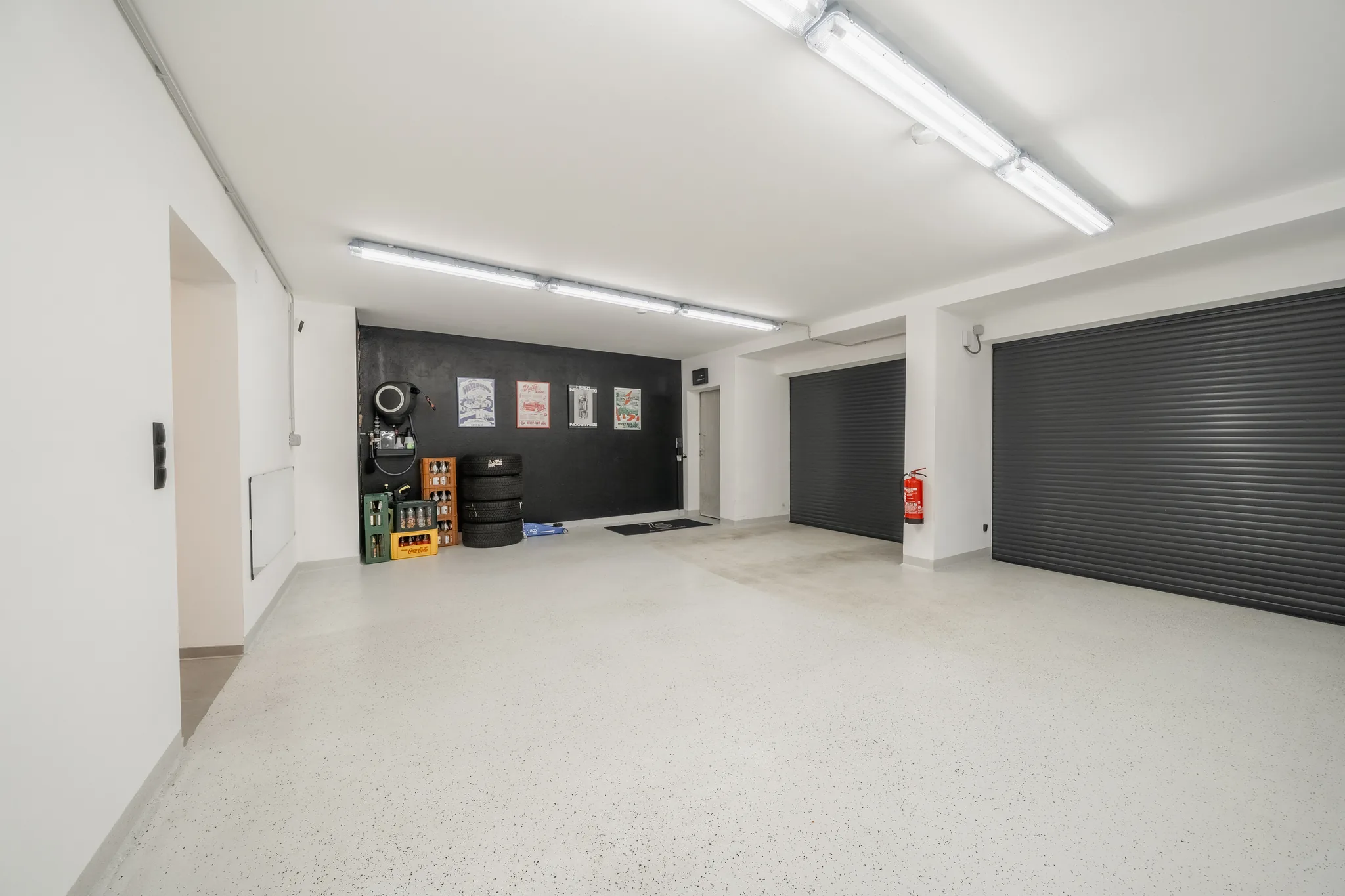 Garage mit hellem Boden, dunkler Rückwand und zwei Rolltoren – Grafenau