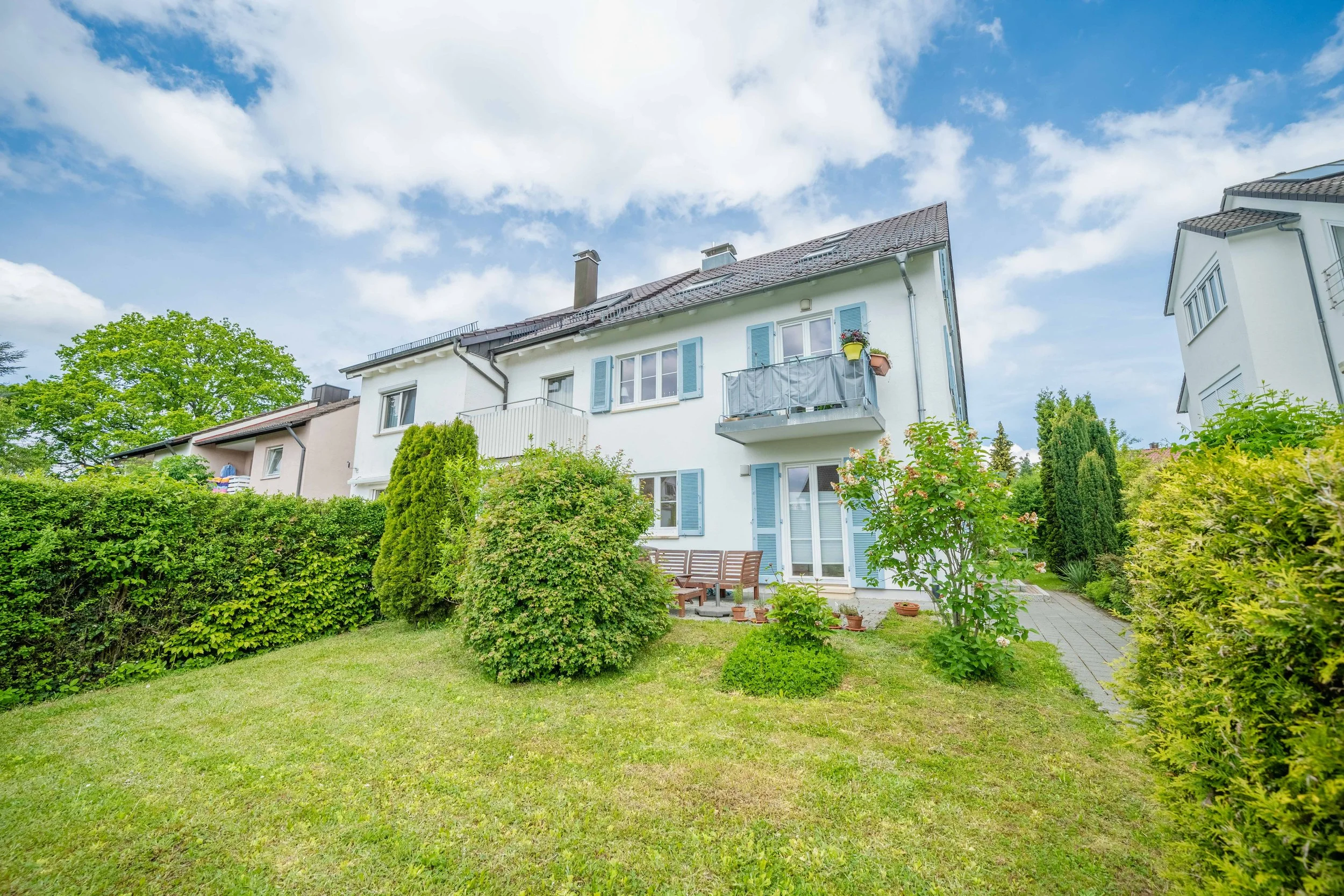 Einfamilienhaus mit gepflegtem Garten und blauen Fensterläden — Außenaufnahme Maurice Veith