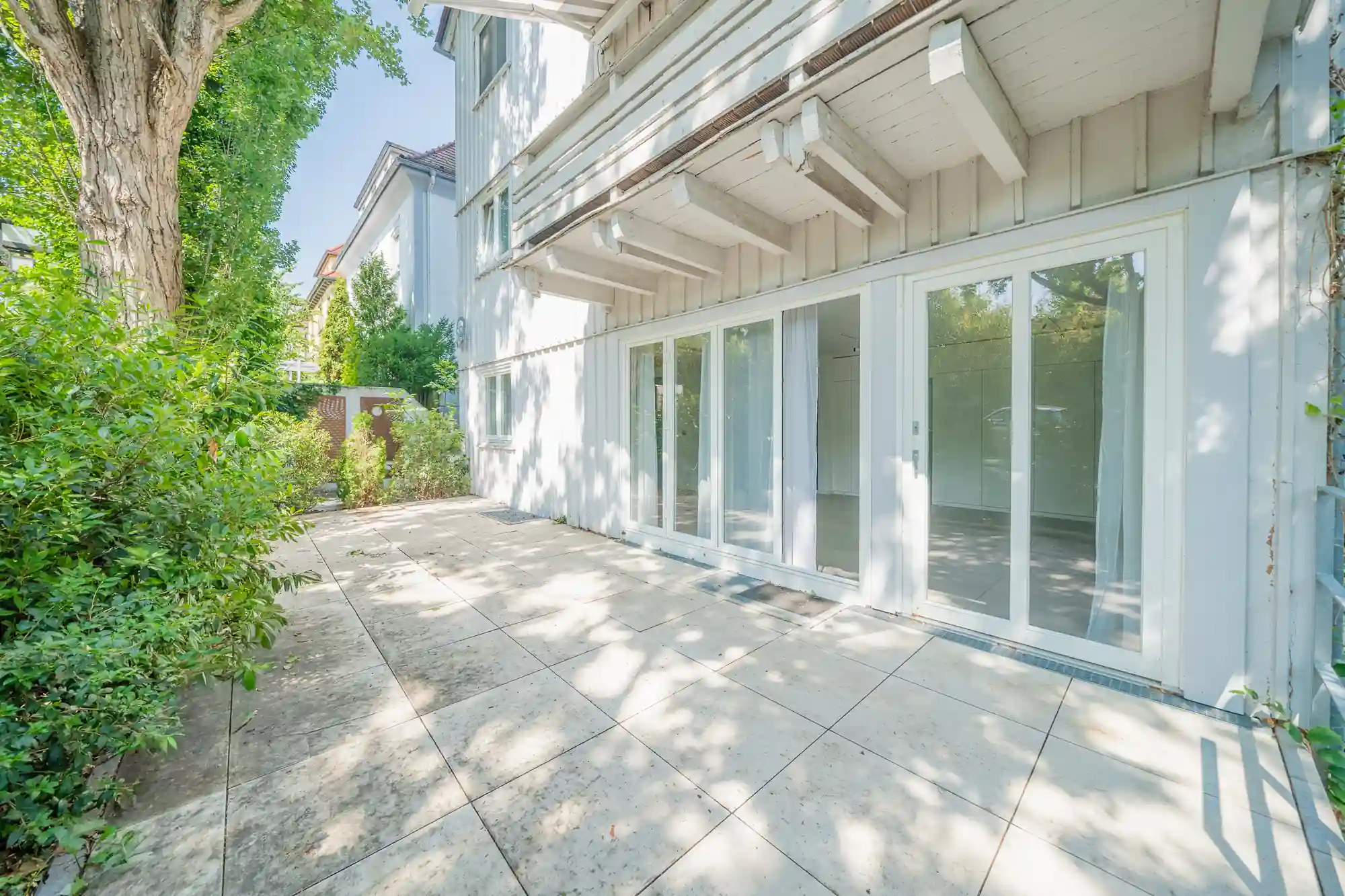 Sonnige Terrasse mit Natursteinplatten unter altem Baum — Außenmotiv für Kurzvideos, MV Media