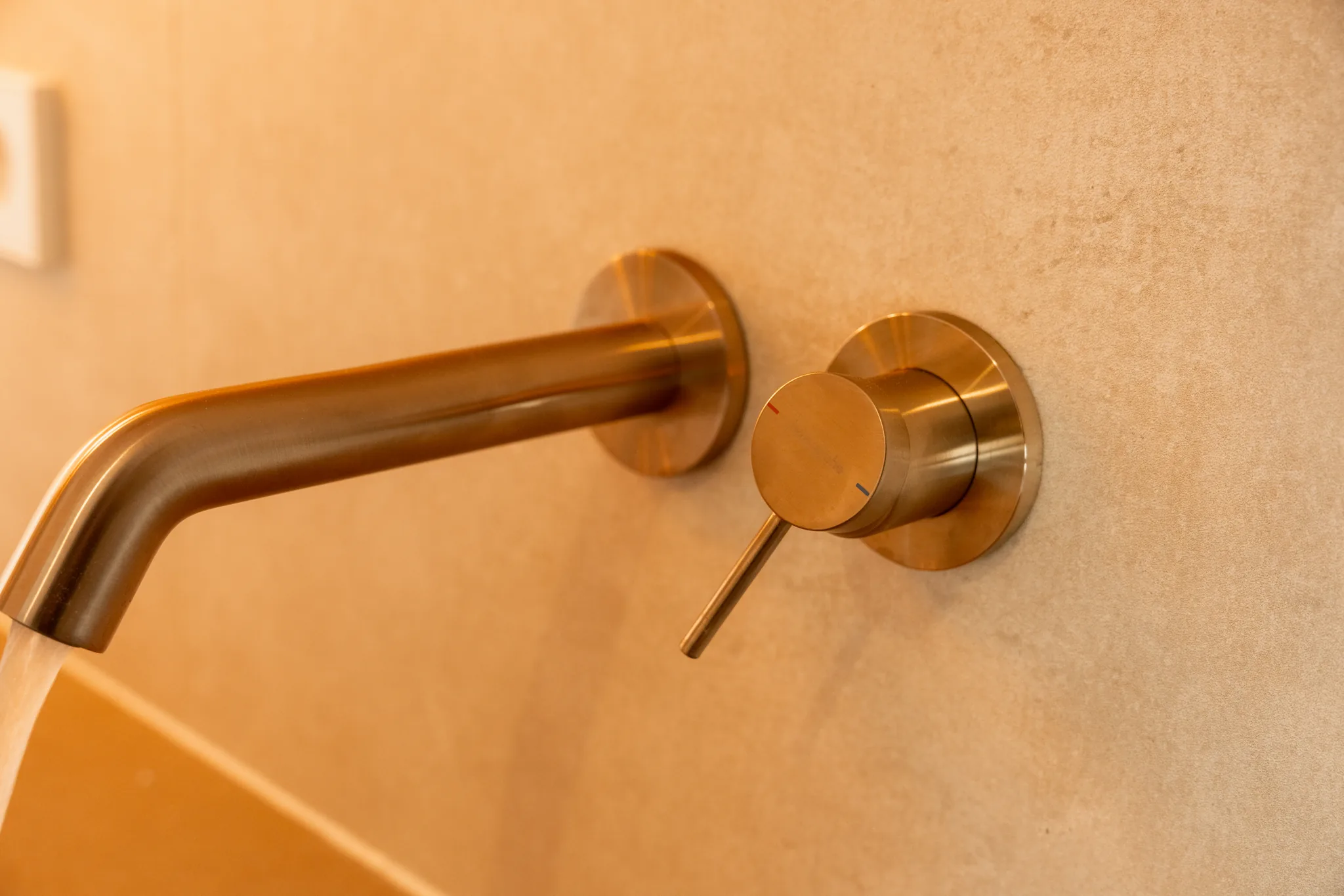 Detailaufnahme einer Wandarmatur aus gebürstetem Messing – Leutenbach