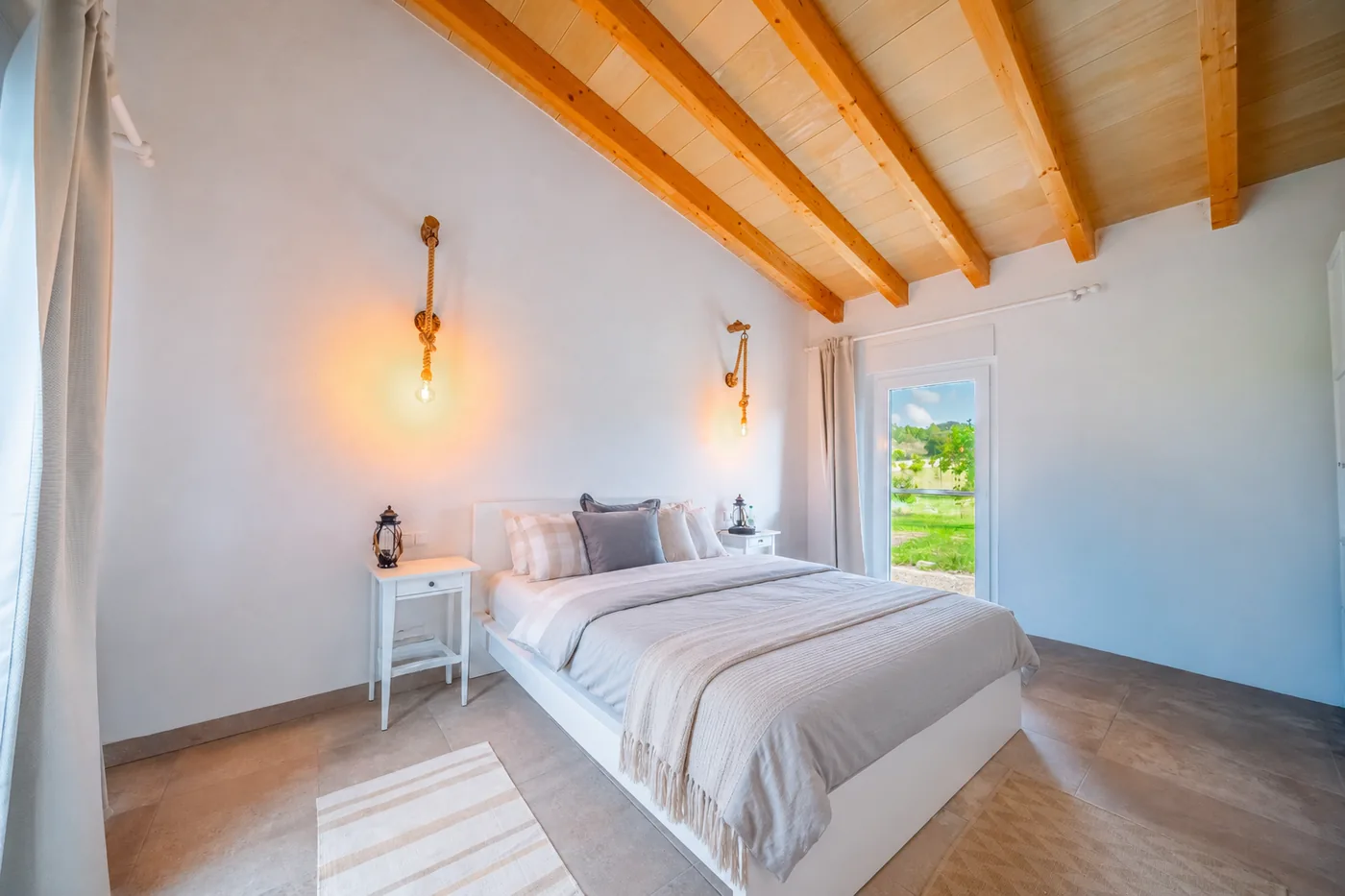 Schlafzimmer mit Holzbalkendecke und Seilleuchten