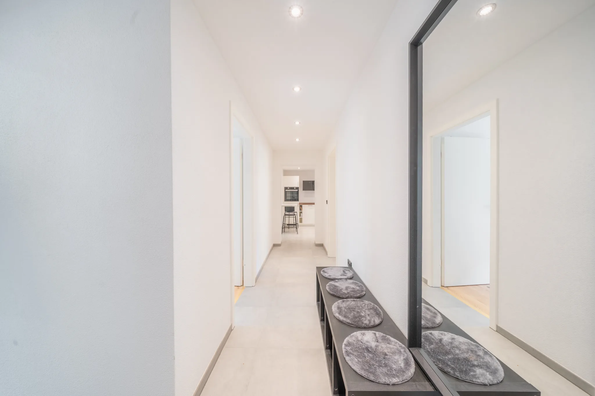 Langer Flur mit Garderobe und Blick bis in die Küche – München-Bogenhausen