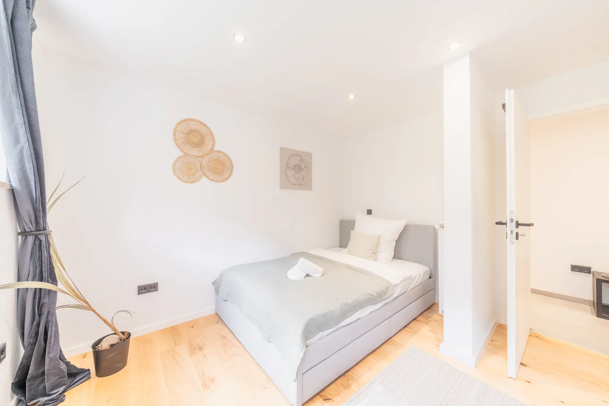 Helles Zimmer mit Bett und Wanddeko – München-Bogenhausen