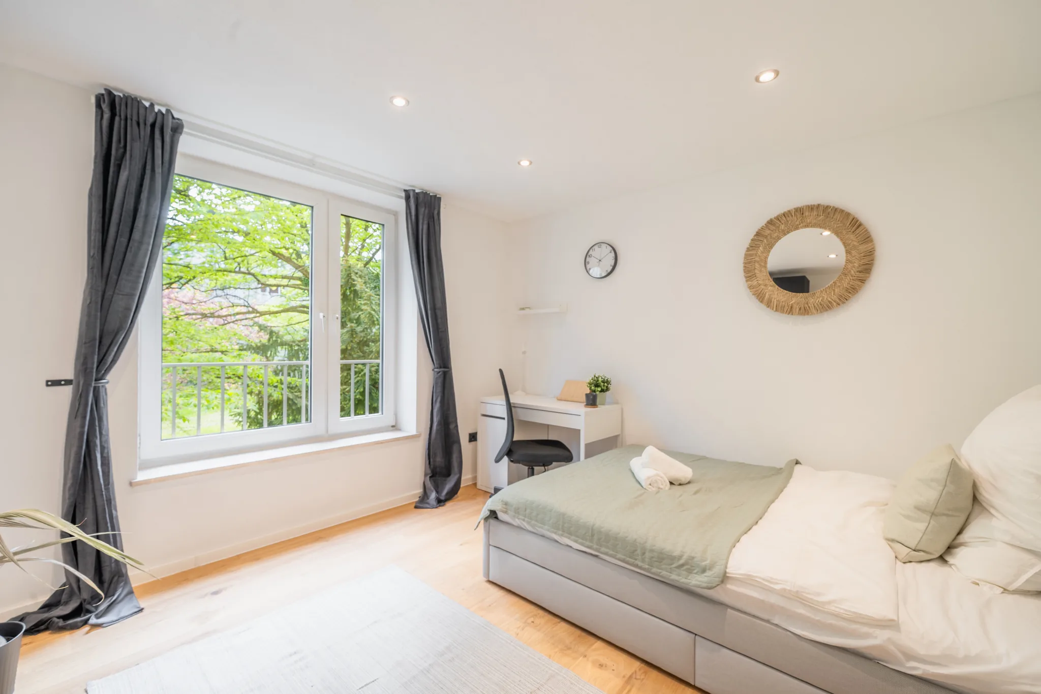Zimmer mit Bett und großem Fenster ins Grüne – München-Bogenhausen