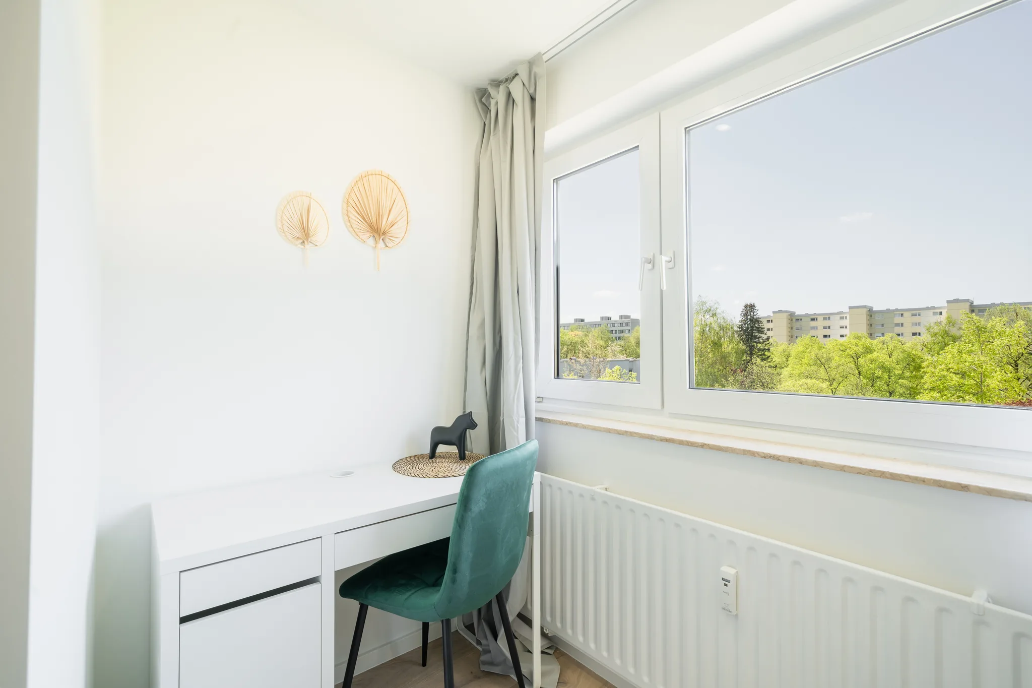 Schreibtisch am Fenster mit Blick ins Grüne – München
